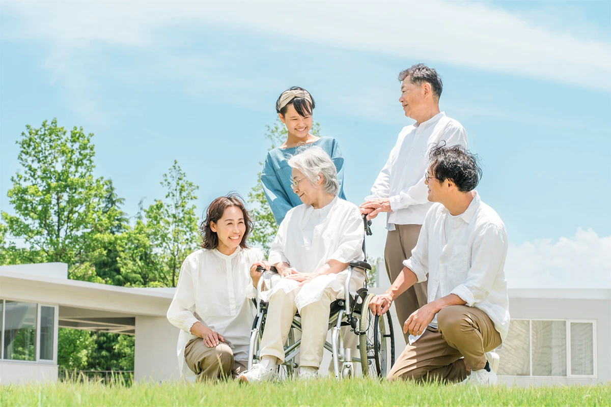 車椅子に座った高齢女性と家族